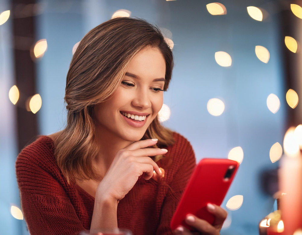 Kobieta prowadzi wideorozmowę korzystając z sieci 5G. Rozmowa trwa w trakcie świąt z rodziną, która mieszka daleko