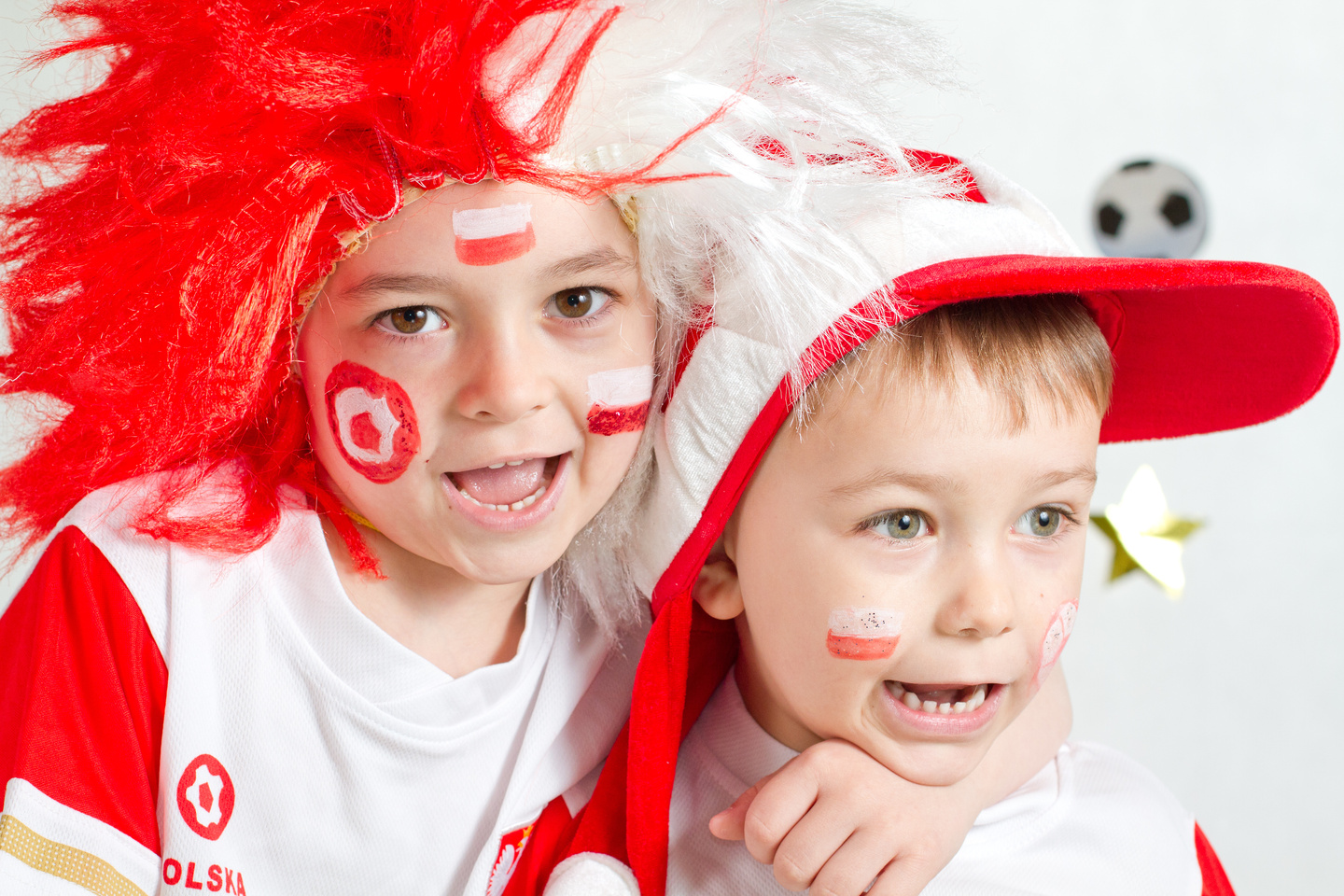 Chłopcy ubrani w barwy Polski kibicują podczas meczu siatkówki