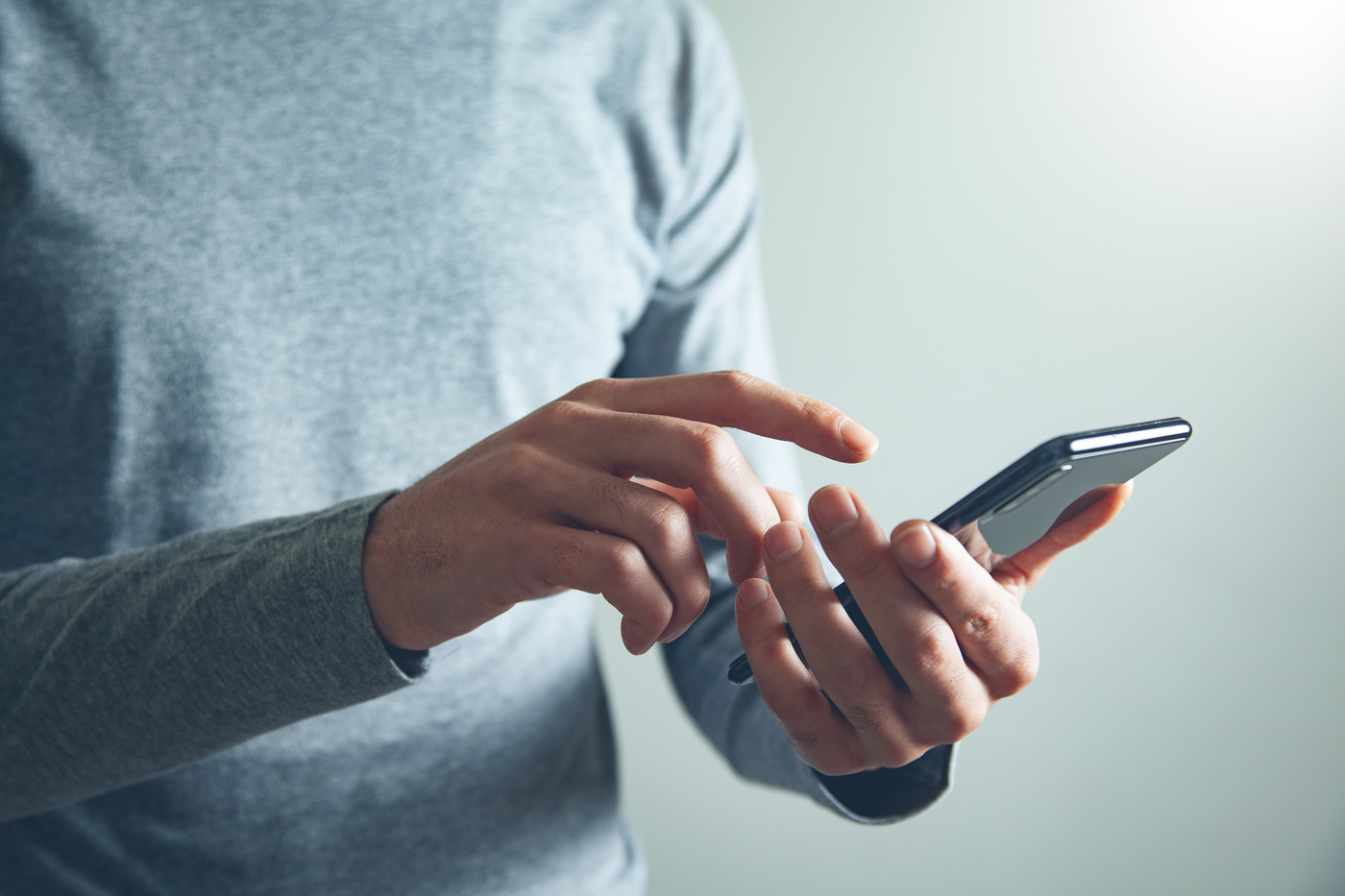 Mężczyzna, który trzyma w dłoni telefon