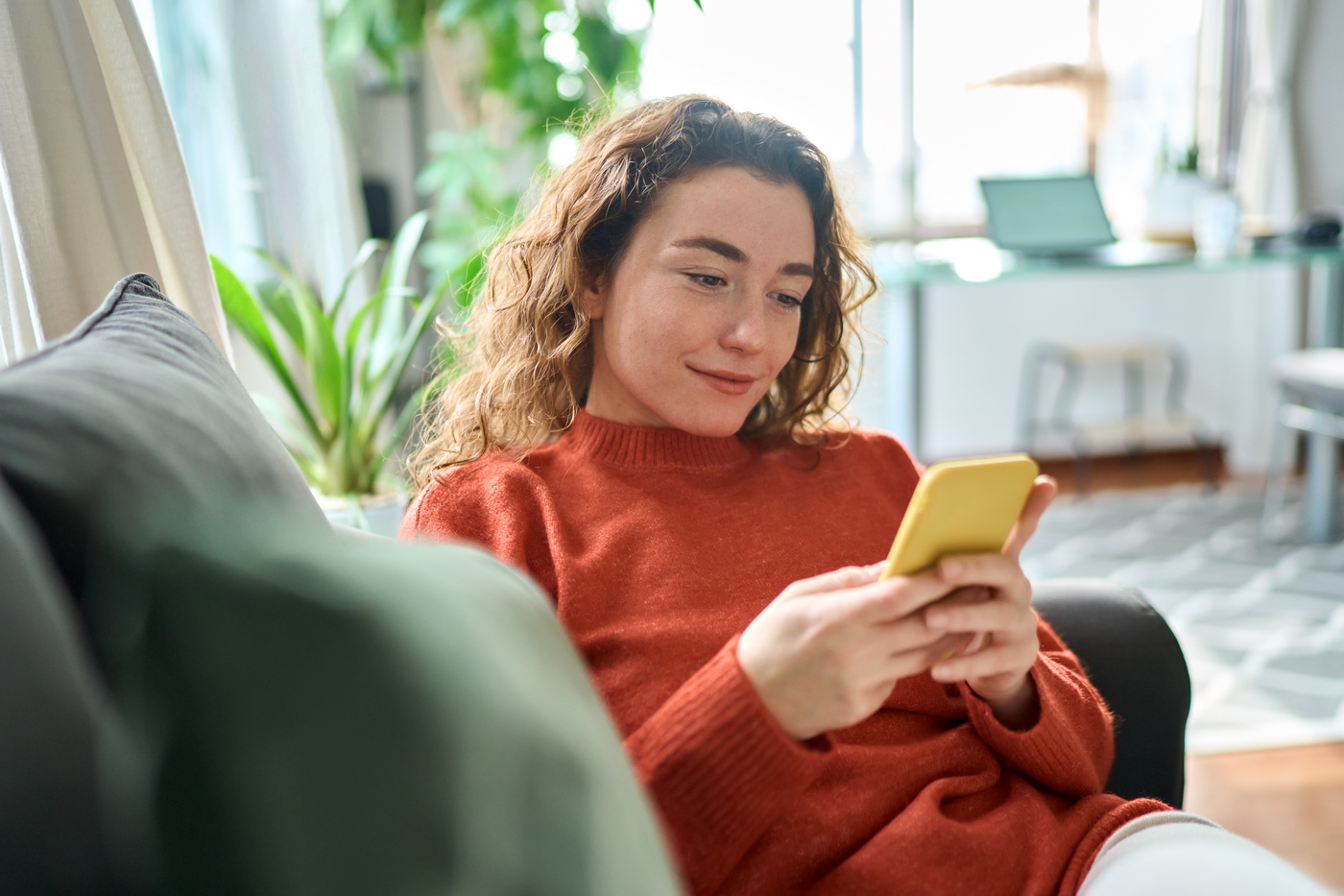Kobieta trzymająca w ręku telefon z zasięgiem 5G.