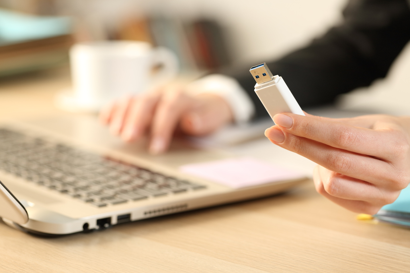 Mężczyzna chce podłączyć złącze USB do laptopa.