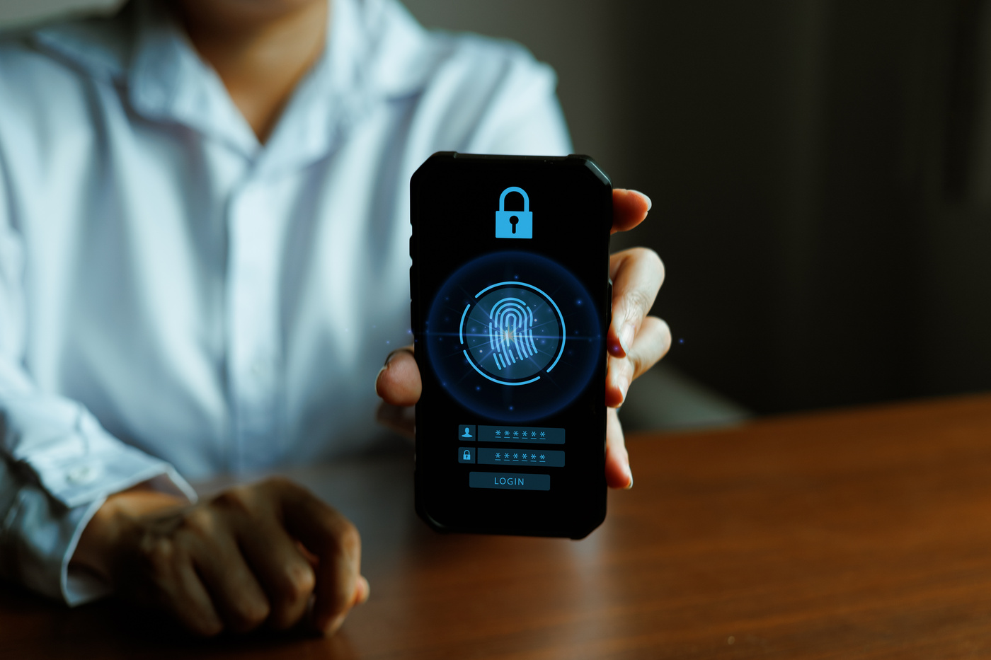 Mężczyzna trzyma smartfon z biometrycznym uwierzytelnianiem odcisku palca i interfejsem logowania bez hasła, podkreślając bezpieczeństwo mobilne, bezpieczny dostęp i ochronę cyfrowej tożsamości.