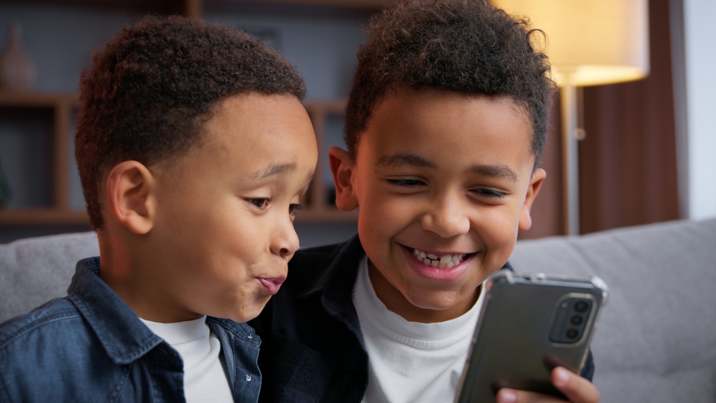 Dzieci korzystają z telefonu, na którym włączona jest Ochrona Internetu oraz Stop Hejt jako formy kontroli rodzicielskiej.
